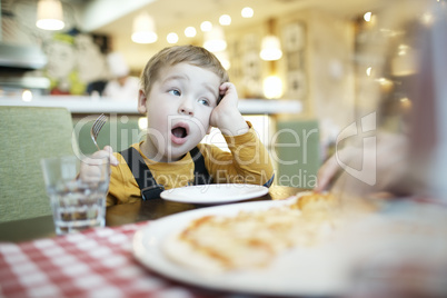 young boy yawning as he waits to be fed