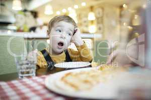 young boy yawning as he waits to be fed