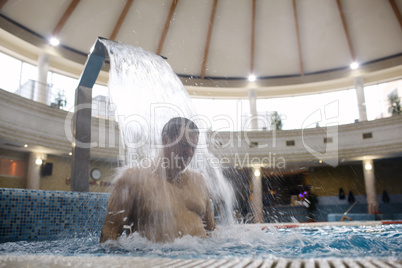 man under water stream in the swimming pool