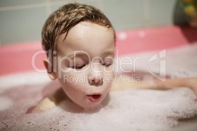 little boy enjoying a foamy bubble bath