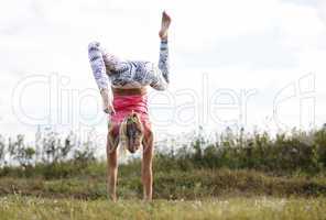 agile young woman doing a handstand