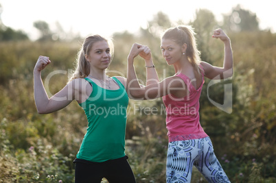 two athletic girls flexing their arm muscles