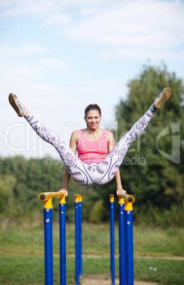 athletic gymnast exercising on parallel bars
