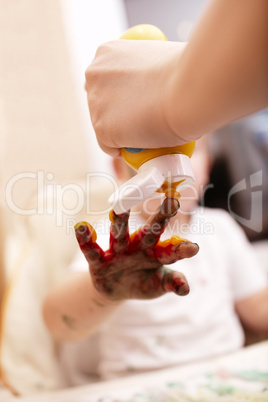 young child playing with finger paint