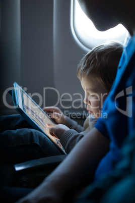 little boy playing with a tablet in an airplane