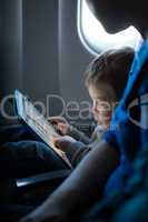little boy playing with a tablet in an airplane