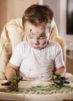 creative little boy playing with finger paint
