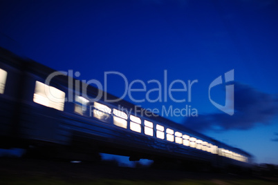 illuminated train traveling past at night