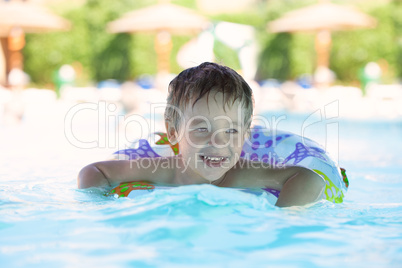 kid learns to swim using a plastic water ring