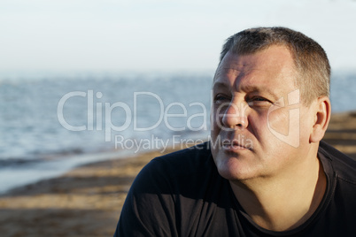 handsome middle-aged man thinking at the beach