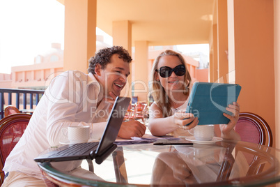 young couple relaxing over coffee on a balcony