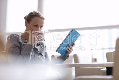 woman in cafe using her touchpad