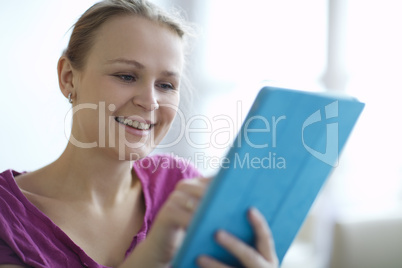 young woman smiling as she surfs the internet