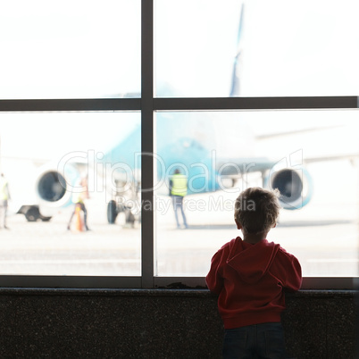 boy looks at the plane at the airport