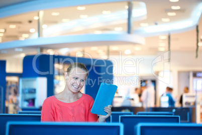 woman sitting in a waiting room reading tablet