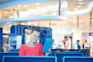 woman sitting in a waiting room reading tablet