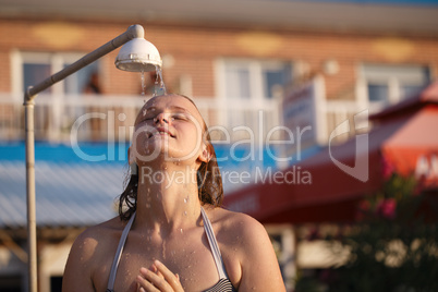 woman rinsing of at the beach under a shower
