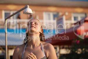 woman rinsing of at the beach under a shower
