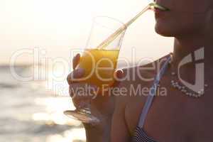 woman sipping a refreshing cocktail at sunset