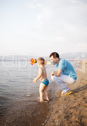 young father playing with his son at the beach