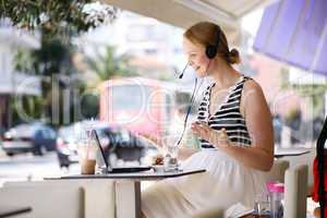 laughing woman wearing a headset in outdoor cafe