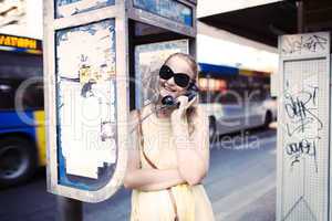woman chatting on a public telephone