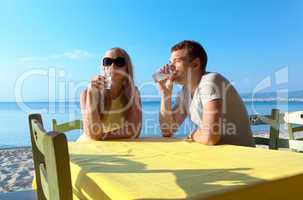 young couple enjoying drinks at the seaside