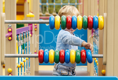 little boy playing with an abacus