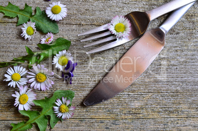 gänseblümchen auf einer gabel auf holzhintergrund