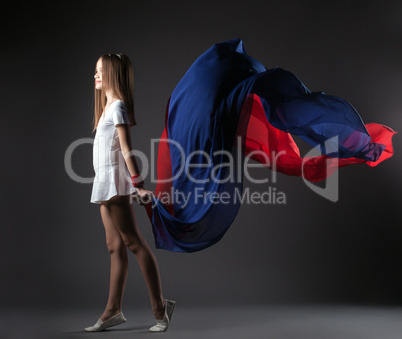 Graceful little athlete posing with colorful cloth