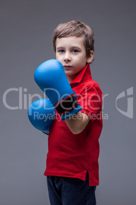Serious handsome boy posing in boxing gloves