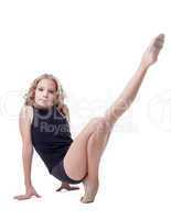 Cute young gymnast doing stretching exercises