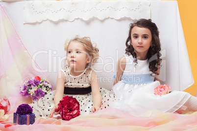 Smart little sisters posing in decorated studio
