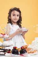 Adorable brown-eyed girl posing with sweets