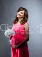 Happy elegant pregnant woman smiling at camera
