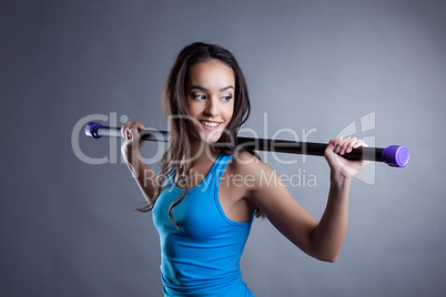 Beautiful smiling brunette posing with fitbar