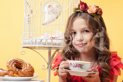 Adorable smiling girl posing with cup of tea