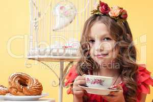 Adorable smiling girl posing with cup of tea