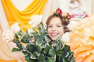 Happy little girl posing with big bouquet of roses