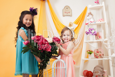 Pretty little girls posing with bouquet of peonies