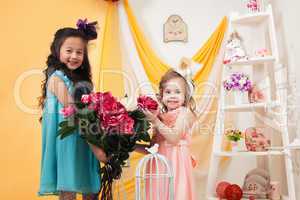 Pretty little girls posing with bouquet of peonies