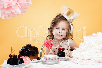 Cute girl posing with sweets, on yellow background