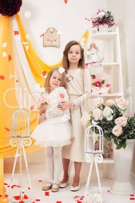 Pretty stylish sisters posing in vintage interior