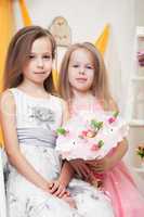 Cute little sisters posing with bouquet of toys