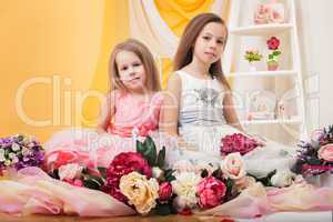 Pretty twins posing with flowers in studio