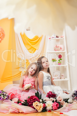 Studio shot of pretty sisters posing with flowers