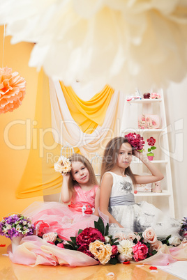 Smart girls posing with flowers in vintage studio