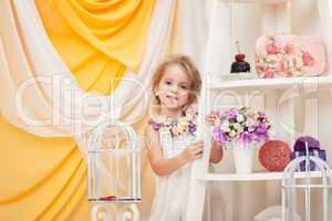 Smiling little girl posing in decorated studio