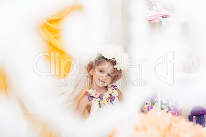 Cute little girl posing in flower wreath, close-up