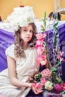 Pretty little girl posing with flower arrangements